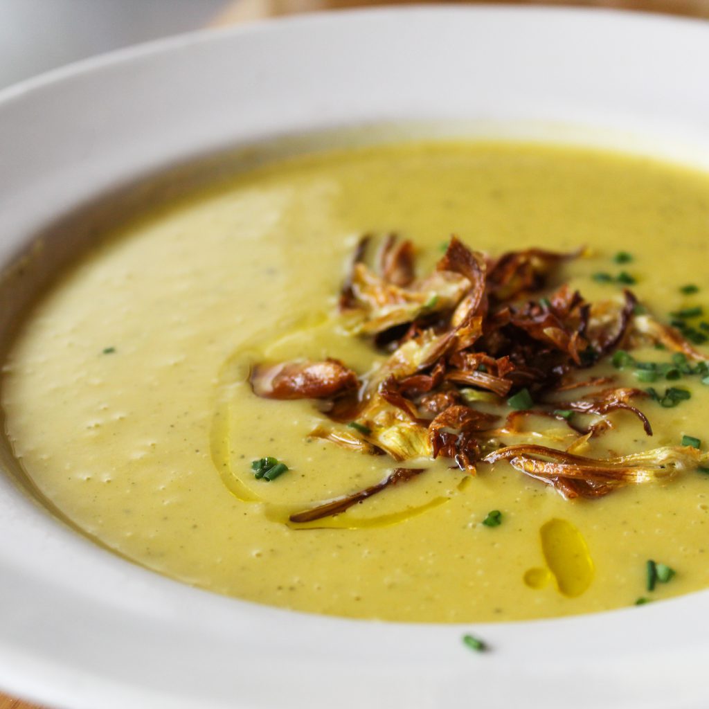 Crema de verduras de la estación con chips de alcachofa.