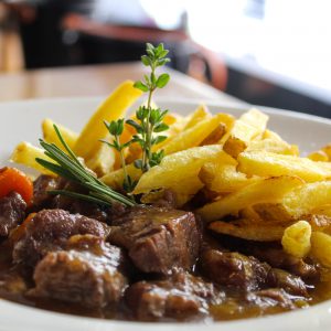 Carrillera de cerdo estofada con vino tinto acompañada de patatas fritas