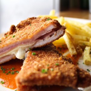 Lomo empanado relleno de jamón y queso acompañado de patatas fritas y salsa de tomate casera