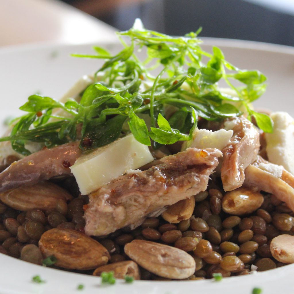 Ensalada de lentejas, almendras, perdiz escabechada, queso de cabra y aliño de miel