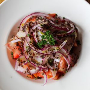 Ensalada de tomate, pepinillos, cebolla y bacalao ahumado con tapenade de aceituna negra