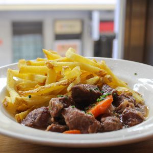 Carrilleras de cerdo estofadas con verduras y patatas fritas