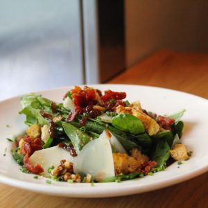 Ensalada de espinacas frescas con bacon parmesano nueces picatostes con aliño de miel y tomate