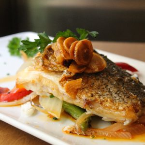 Merluza sobre verduras salteadas con refrito de ajo y pimentón