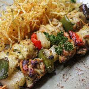Brochetas de pollo y verduras con patata paja
