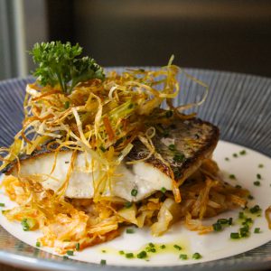 Corvina sobre repollo salteado con ajo y pimentón