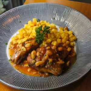 Pollo estofado en su jugo con almendras, acompañado de patatas fritas